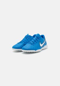 Blue sports shoes with a textured upper, white rubber sole, and a sleek design featuring a prominent white logo and subtle gray accents.