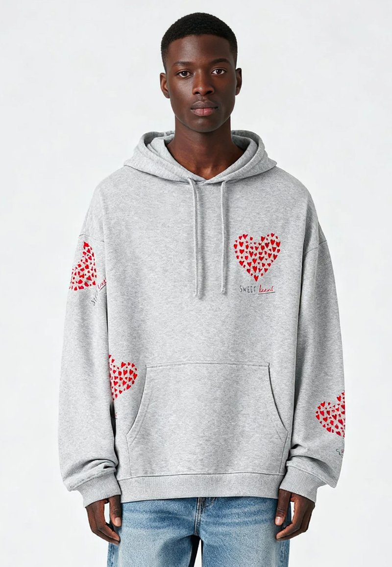 Siv hoodie z več rdečimi srčnimi vzorci, sprednjim žepom in kapuco s vrvico. Narejen iz mehkega materiala z rebrastimi manšeti in robom.