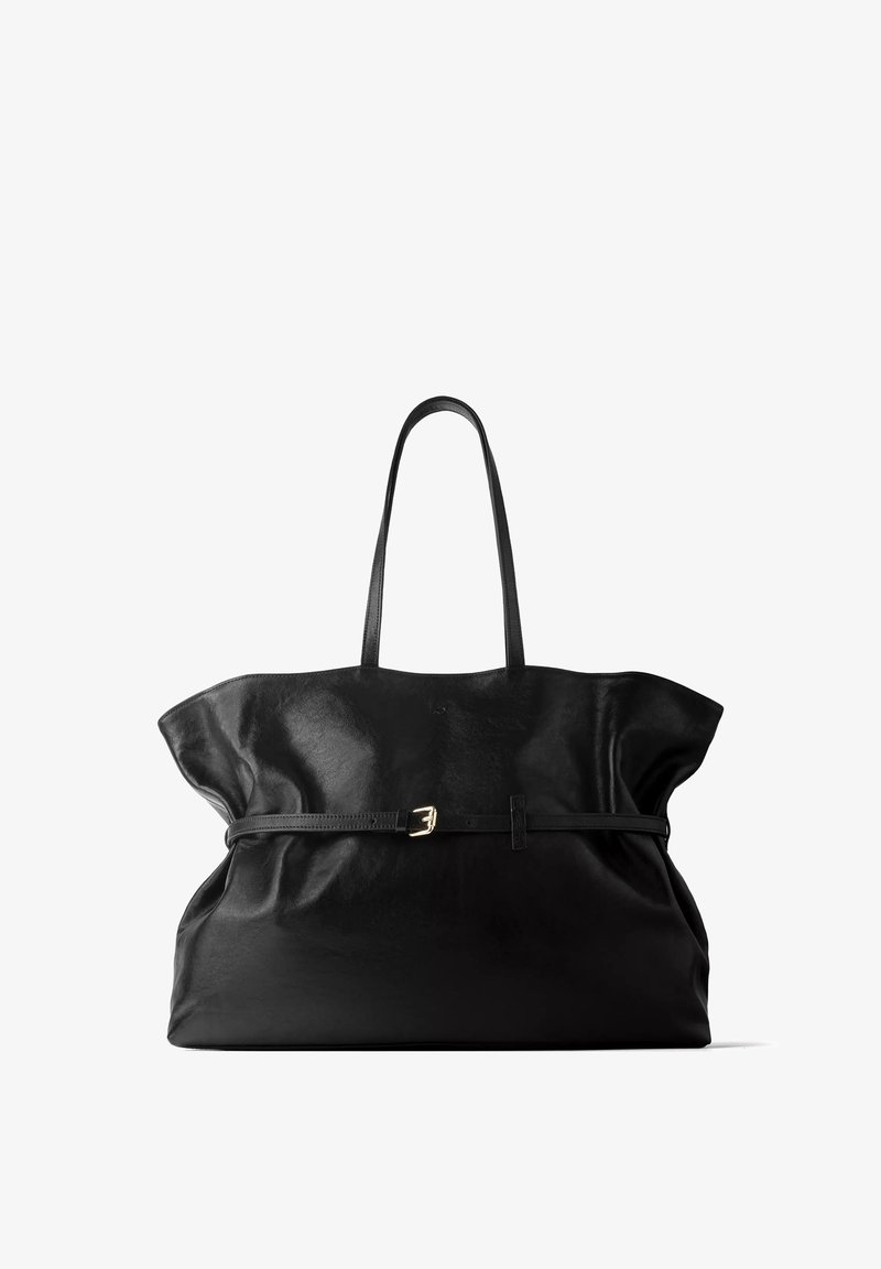 Grand sac cabas en cuir noir avec de fines bretelles et une ceinture fine avec une petite boucle dorée au milieu.