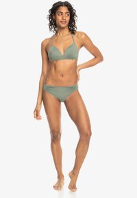 Khaki grön bikini-set som har en triangeltopp och en rynkad högmidjad botten, tillverkad av mjukt, stretchigt tyg. Minimalistisk design.