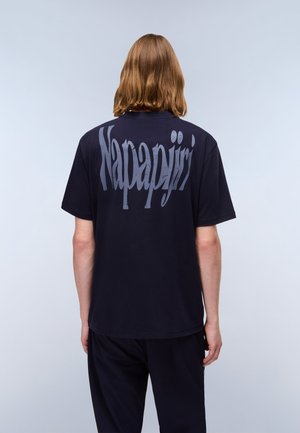 T-shirt blu navy con grande scritta grigia "Napapijri" sul retro. Collo rotondo, maniche corte e vestibilità rilassata. Materiale in cotone morbido.