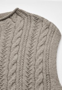 Beige stickad tröja med kabelmönster, rundad halsringning och textil med struktur samt ribbade detaljer längs kanterna.