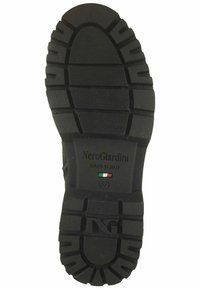 Black rubber shoe sole with prominent treads, textured surface, and engraved brand name "NeroGiardini" along with Italian flag and size 37.