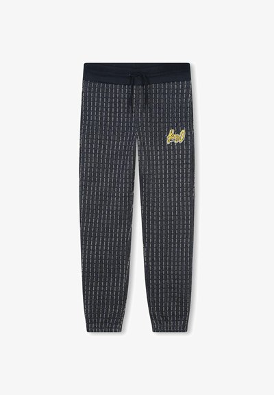 Des joggings bleu marine présentent un motif rayé vertical, une taille élastique avec cordon de serrage, et un logo brodé jaune sur la cuisse.