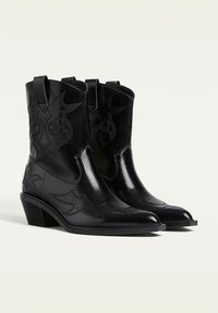 Stivali da cowboy in pelle nera con punta affusolata, tacco basso a blocco e motivi decorativi ricamati sulla canna.