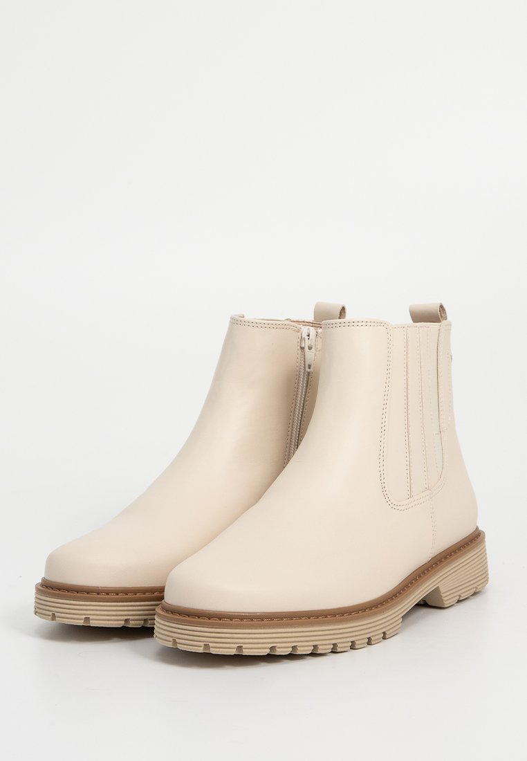 Ein Paar beige Lederankelstiefel mit seitlichem Reißverschluss, elastischem Einsatz, Zuglasche und strukturiertem Gummisohle auf weißem Hintergrund.