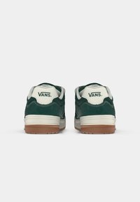 Grüne Wildleder-Sneaker mit niedrigem Profil, weißen gepolsterten Kragen, cremefarbenem Zwischensohlen und Gummisohle. Markenlogo am Fersenbereich sichtbar.