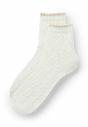 Para białych skarpetek do kostek z subtelnym kwiatowym wzorem dzianym i cienką beżową lamówką przy mankiecie, ułożonych płasko na białym tle.