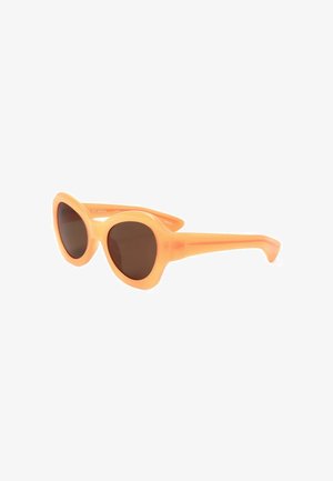 Occhiali da sole rotondi stile cat-eye con montatura spessa color pesca e lenti scure, mostrati leggermente inclinati su sfondo bianco.