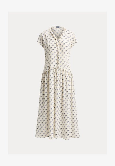 Kermanvärinen lyhythihainen mekko sinisellä kukkakuviolla, napitettu edestä, röyhelöyksityiskohdilla ja kerätty midi-lenkkinen hame.