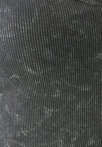 Black ribbed fabric with a slight sheen, featuring vertical lines and a smooth texture. Material appears stretchy and form-fitting.