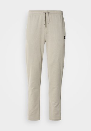 Beiga joggers av mjukt tyg, med elastiskt midjeband, dragsko och två framfickor. Minimalistisk design med sidostygn.