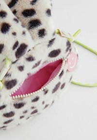 Faux fur-väska med leopardmönster, rosa foder och dragkedjestängning. Har en grön rem och en rund rosa charm med ett glatt ansikte.