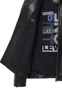 Zwarte leren jas met een ritssluiting. De binnenkant heeft een zwarte voering met blauwe en witte teksten en graphics. Inclusief een zak.