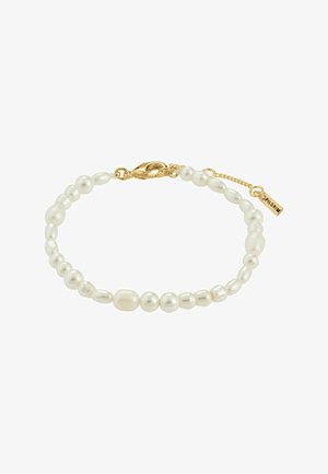 Bracelet en perles comportant des perles blanches de différentes tailles avec un fermoir en or et une petite étiquette. Texture lisse, design simple et formes variées.