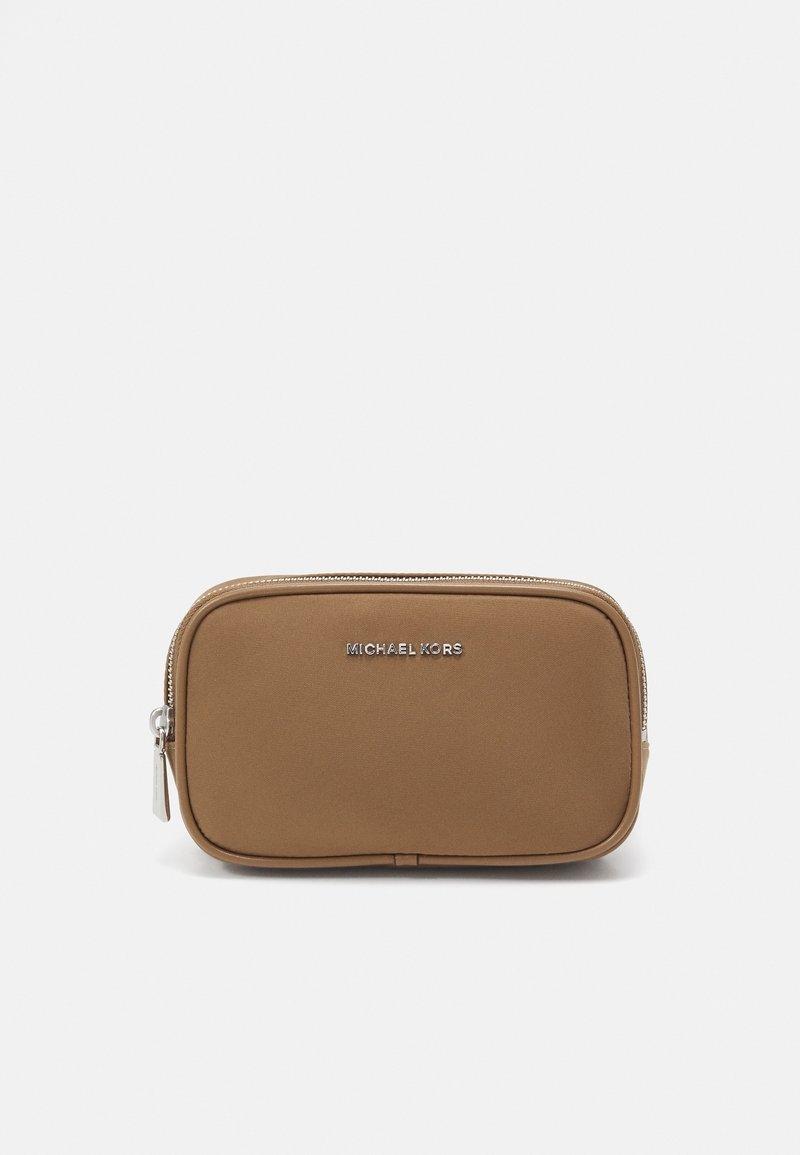 Pochette en tissu beige de forme rectangulaire, avec une fermeture éclair argentée et le logo 'MICHAEL KORS' à l'avant. Texture lisse et design minimaliste.