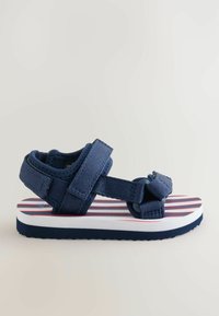 Sandale pour tout-petit bleu marine avec sangles ajustables et semelle blanche, dotée d'une semelle intérieure rayée rouge et blanche.