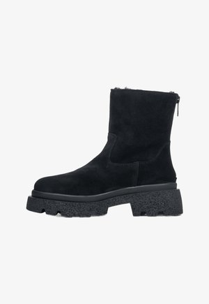 Black suede ankle boots with a textured rubber sole, side zipper, and a slightly elevated platform for added height.