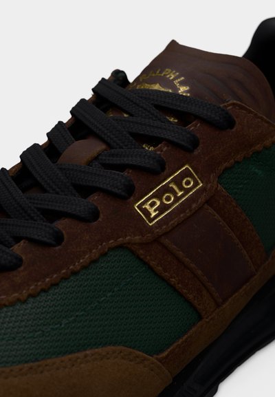 Hnědá a zelená teniska s texturovaným svrškem, černými tkaničkami a zlatým logem "Polo", vyrobená z kombinace kůže a látky.