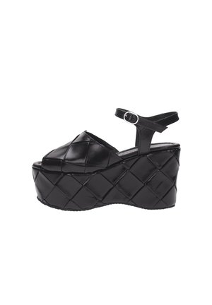 Sandale à plateforme en cuir matelassé noir avec bride cheville et boucle argentée, bout ouvert et semelle épaisse rembourrée.