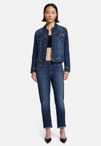 Giubbotto di jeans con un design cropped, tasche frontali e chiusura a bottoni, abbinato a jeans denim a gamba dritta. Entrambi in una tonalità blu scuro.