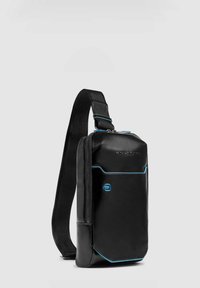 Borsello a tracolla nero con trama, dettagli blu, dotato di chiusura con zip e spallaccio regolabile. Design compatto, adatto per trasportare gli oggetti essenziali.