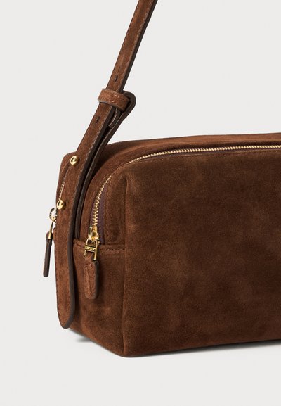 Borsa a tracolla in suede marrone con zip dorata, finitura testurizzata e tracolla regolabile. Presenta una tasca laterale con zip per ulteriore spazio di archiviazione.