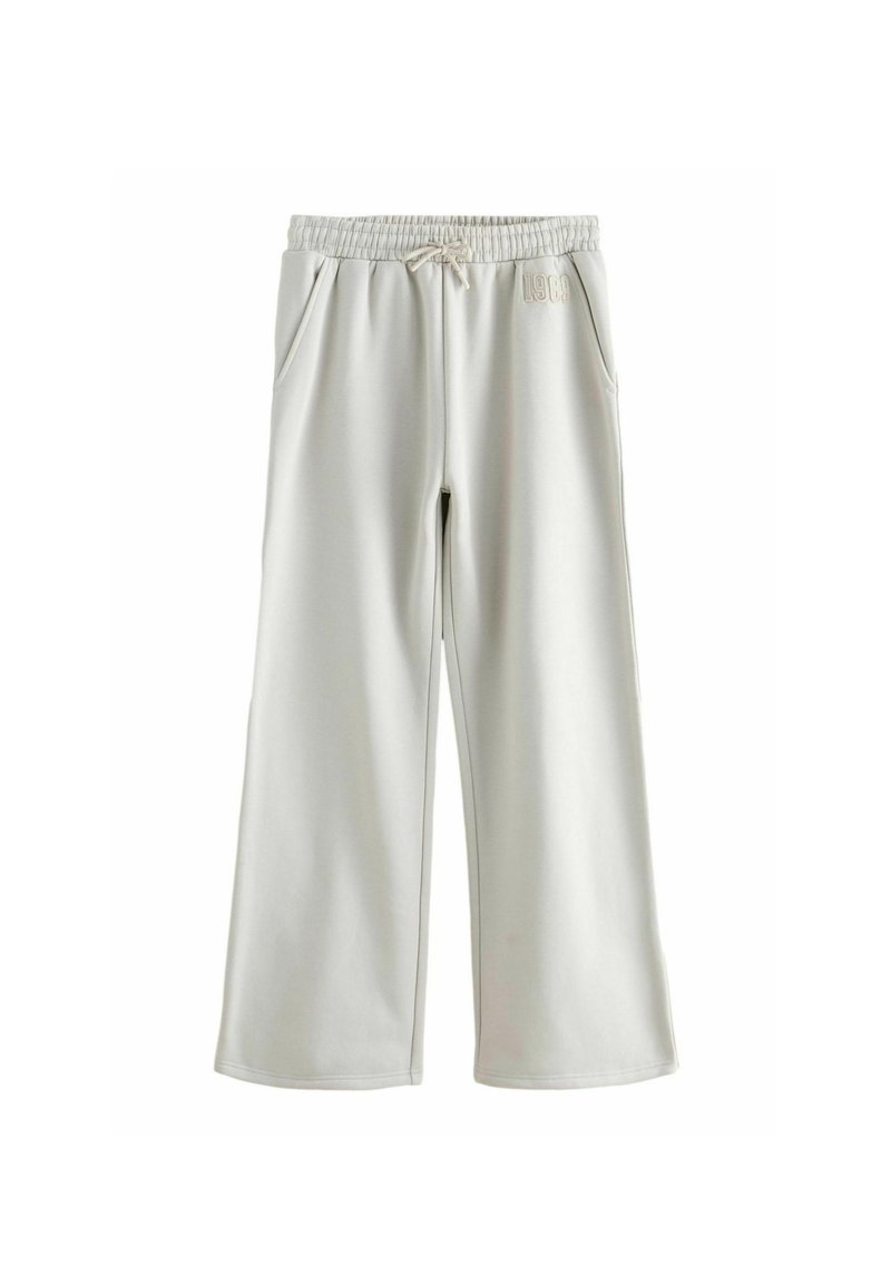 Široké svetlé šedé teplákové nohavice vyrobené z jemného materiálu, s elastickým pásom, šnúrkou a bočnými vreckami. Výrazné logo na boku.