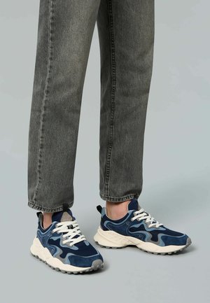 Sneaker blu navy realizzati con materiali misti tra cui suede e mesh, caratterizzati da una suola intermedia testurizzata, lacci bianchi e un design con pattern.