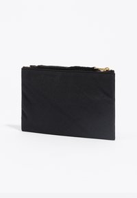 Bolsita rectangular negra hecha de tela texturizada, con un zipper superior con herrajes dorados para el cierre. Diseño simple y funcional.