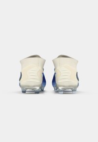 Chuteiras de futebol azuis com um design texturizado, realces brancos e cravos transparentes. Colarinho alto para suporte do tornozelo. Vista traseira.
