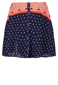 Jupe à boutons sur le devant avec des motifs géométriques bleu marine et blanc, dotée d'une ceinture à motifs orange et blanc.