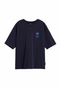 Camiseta de algodón azul marino con mangas cortas, cuello redondo y aberturas laterales. Presenta un diseño gráfico azul claro en el pecho.