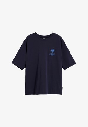 Tumesinine puuvillane T-särk lühikeste varrukatega, ümar kaelus ja külgmised lõhed. Ees on kerge sinise värviga graafiline disain.