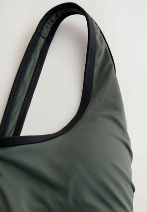 Top de baño verde con una superficie texturizada y acanalada. Presenta un acabado negro en los tirantes y el escote para contraste.