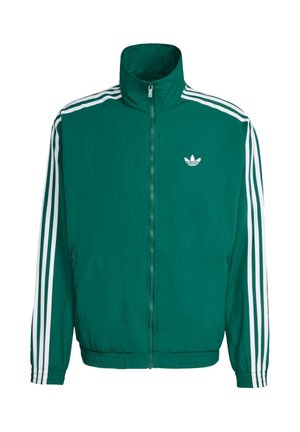Zeleni jakna s kapuljačom, bijeli zatvarač i tri bijele pruge na rukavima. Ima mali bijeli logo na prsima.