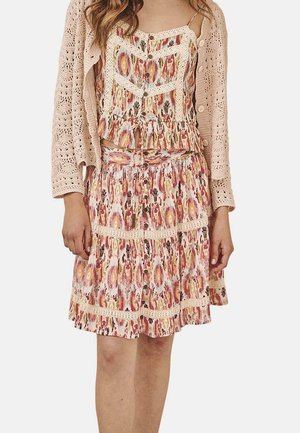 Vestido con estampado floral, con falda en capas y cierre de botones, hecho de tela ligera; combinado con un cárdigan de punto en suave rosa.