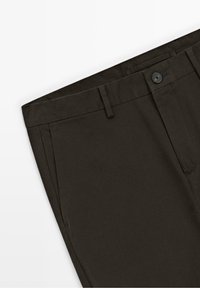 Pantalon habillé marron foncé avec fermeture par bouton, passants de ceinture et poches avant sur fond blanc.