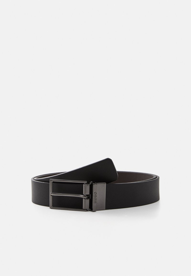 Ceinture en cuir noir avec une finition lisse, dotée d'une boucle en métal argenté et de deux pattes, conçue pour un look épuré et minimaliste.