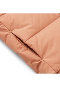 Peach-colored padded fabric with a smooth texture, featuring stitched sections and a side pocket opening.