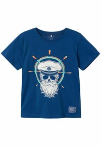 Camiseta de algodón de color azul marino con un gráfico de una calavera con barba y gorra de capitán, rodeada por un diseño circular en naranja y turquesa.
