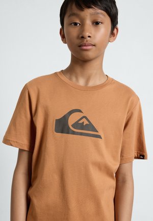Camiseta de algodón marrón de manga corta, con un gran logo de ola negra en la parte frontal y una pequeña etiqueta negra en la manga izquierda.