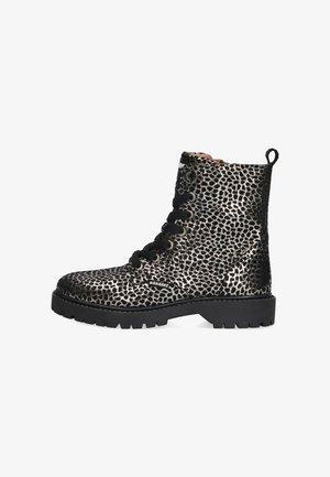 Black and metallic patterned ankle boot with round toe, lace-up closure, and thick black rubber sole. Features loop pull tab at heel.