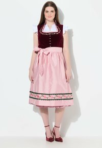 Traditionell österreichisches Kleid mit einem samtigen burgunderfarbenen Mieder, weißen Rüschenärmeln und einem rosa Satinrock, der mit floralen Stickereien und schwarzem Besatz verziert ist.