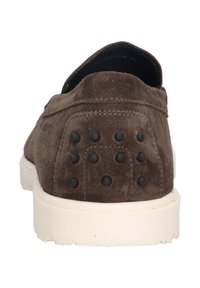 Bruine suède instapper met een textuur, witte rubberen zool en zwarte stipaccenten op de bovenkant van de hak voor extra detail.