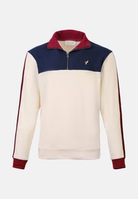 Pull-over crème avec un col zippé, présentant un panneau de poitrine bleu marine et des accents bordeaux sur les manches et le col. Logo brodé sur la poitrine.