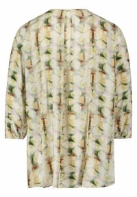Let bluse i en creme- og grønblomstret mønster, med lange ærmer, plisseret ryg og en løs pasform for komfort.
