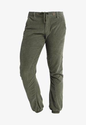 Olívazöld kordbársony nadrág, szűkített fazonnal, húzózsinóros derékkal és gumírozott mandzsettával. Texturált anyag, függőleges redőkkel.