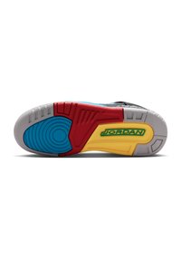 Suola di sneaker colorata con sezioni blu, rosse, gialle e grigie, con un logo verde "JORDAN" sulla parte gialla.