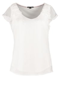 Blouse blanche avec manches courtes volantées, un col rond et une texture lisse. Le design présente une silhouette fluide et un aspect superposé.